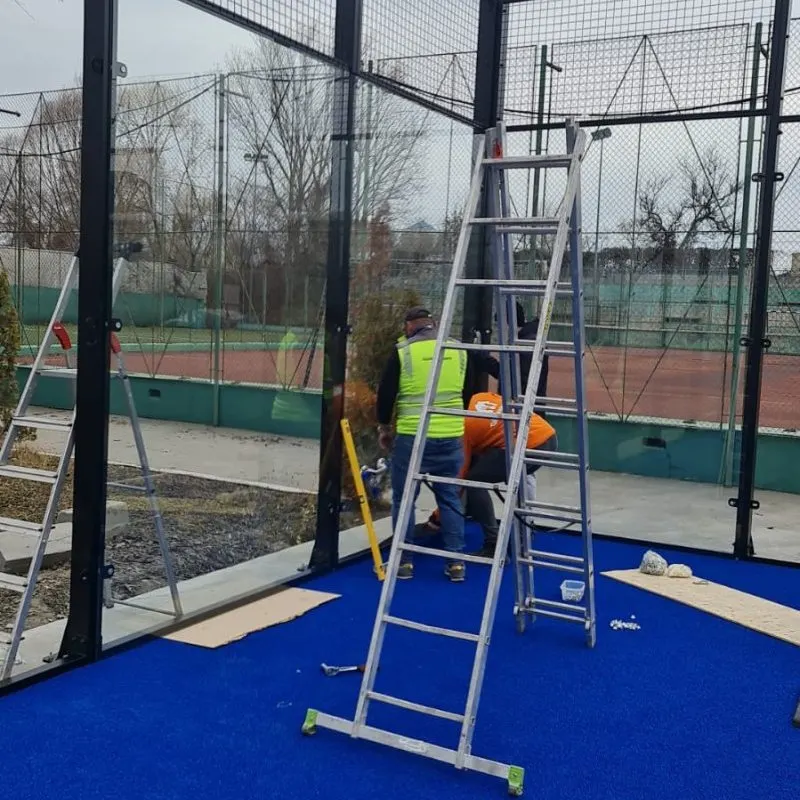 Padel kortunda temperli cam panellerin ve tel örgünün montajı