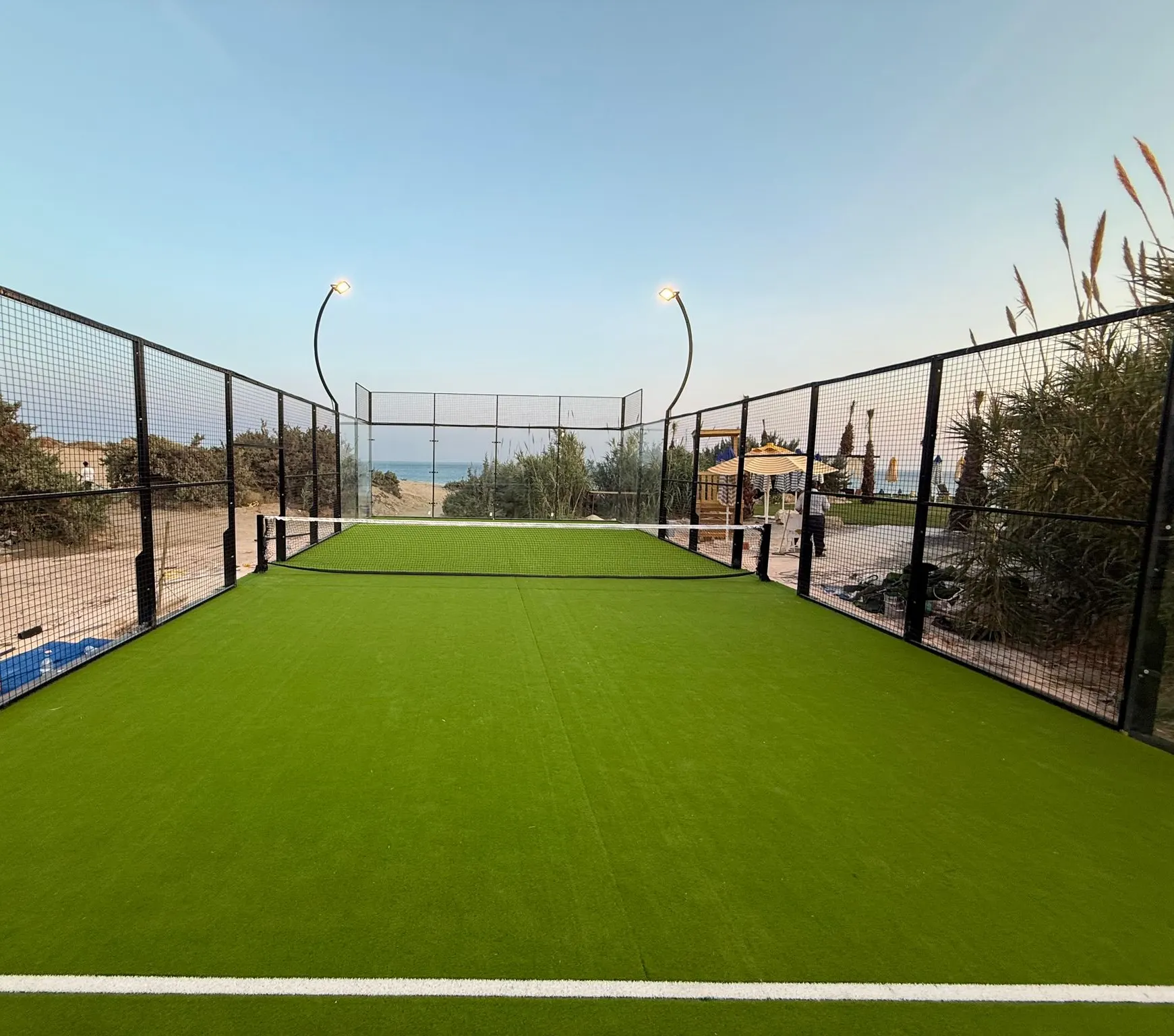 Açık padel kortu, kademeli cam yan duvar ve galvanizli çelik konstrüksiyon