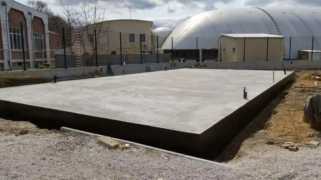 Dökülmüş beton temel plağı ve yerine konmuş ankraj bulonları